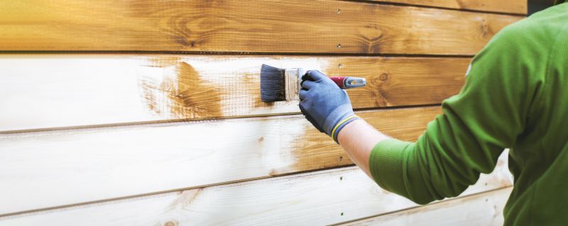 Siding being painted on a modern home